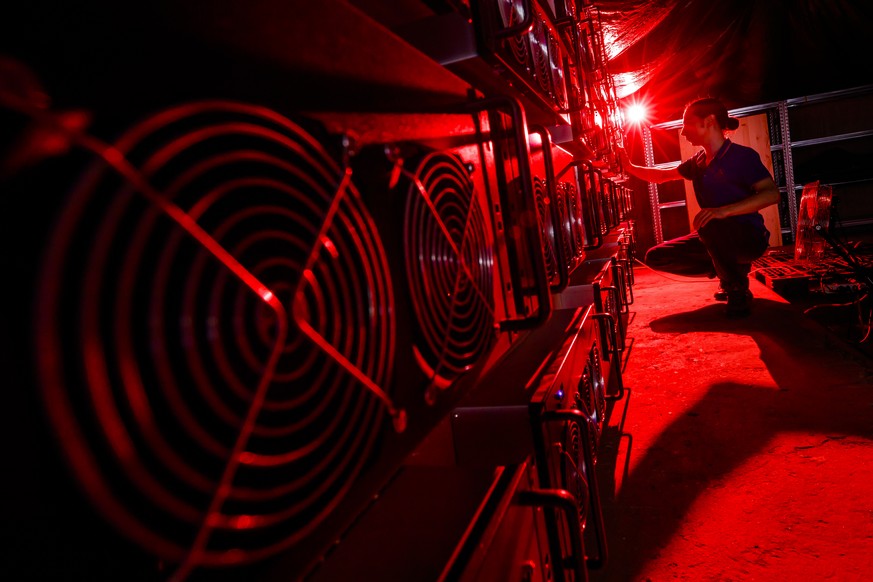 Alpine Mining co founder Theo Martinet performs routine equipment controls on computers in a cryptocurrency mine in the small alpine village of Gondo, Switzerland, Monday, May 7, 2018. The village for ...