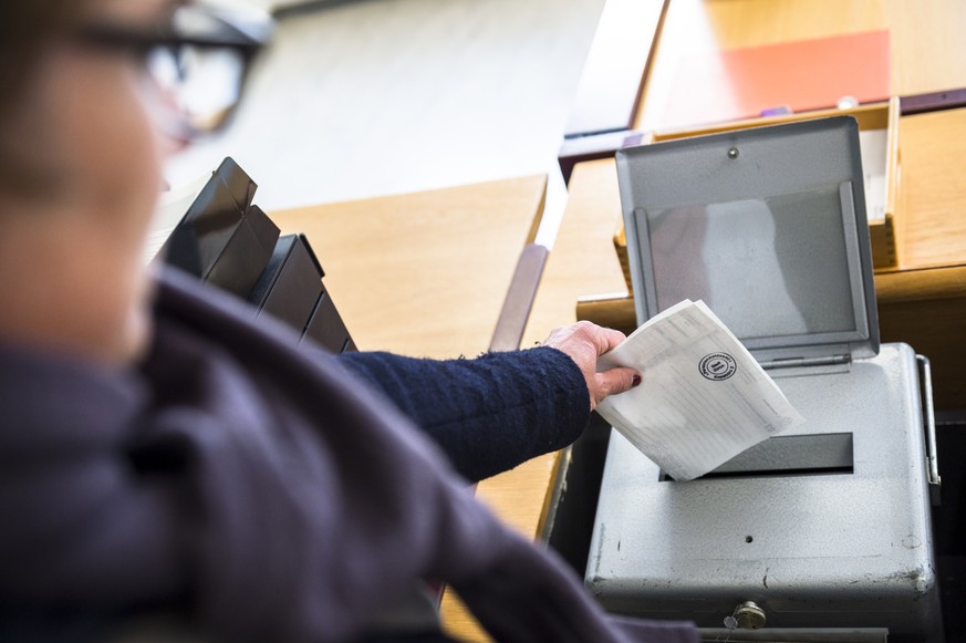 Eine Waehlerin wirft ihren Wahlzettel fuer die Erneuerungswahl der 35 zuercherischen Mitglieder des schweizerischen Nationalrates, Wahl vom 18. Oktober 2015, in die Wahlurne in einem Kreisbuero der St ...