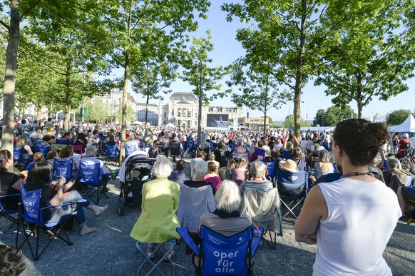 Besucher bei der Liveuebertragung von Rigoletto aus dem Opernhaus auf den Sechselaeutenplatz in Zuerich am Samstag, 21. Juni 2014. Die „Oper für alle“ findet im Rahmen der Festspiele Zuerich statt. (K ...