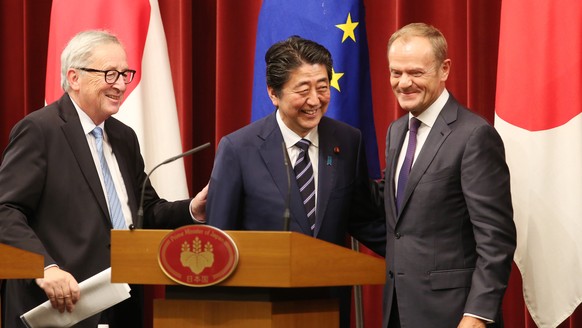 epa06894454 Japanese Prime Minister Shinzo Abe (C), European Commission President Jean-Claude Juncker (L) and European Council President Donald Tusk (R) smile after their joint press conference at Abe ...