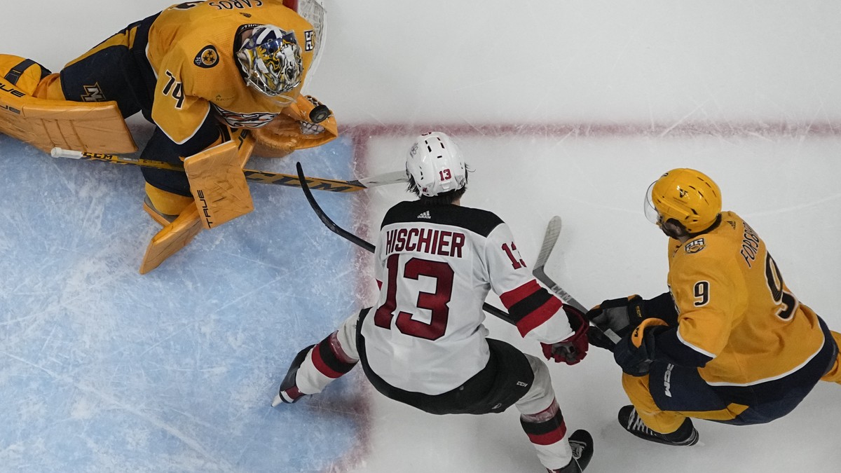Nashville Predators goaltender Juuse Saros (74) blocks a shot on goal by New Jersey Devils center Nico Hischier (13) during the second period of an NHL hockey game Tuesday, Feb. 13, 2024, in Nashville ...