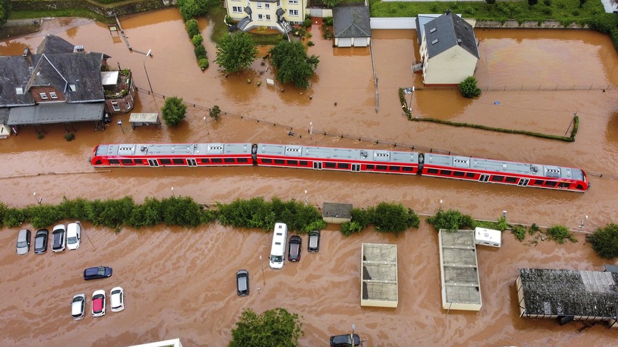 A regional train sits in the flood waters at the local station in Kordel, Germany, Thursday July 15, 2021 after it was flooded by the high waters of the Kyll river. (Sebastian Schmitt/dpa via AP)