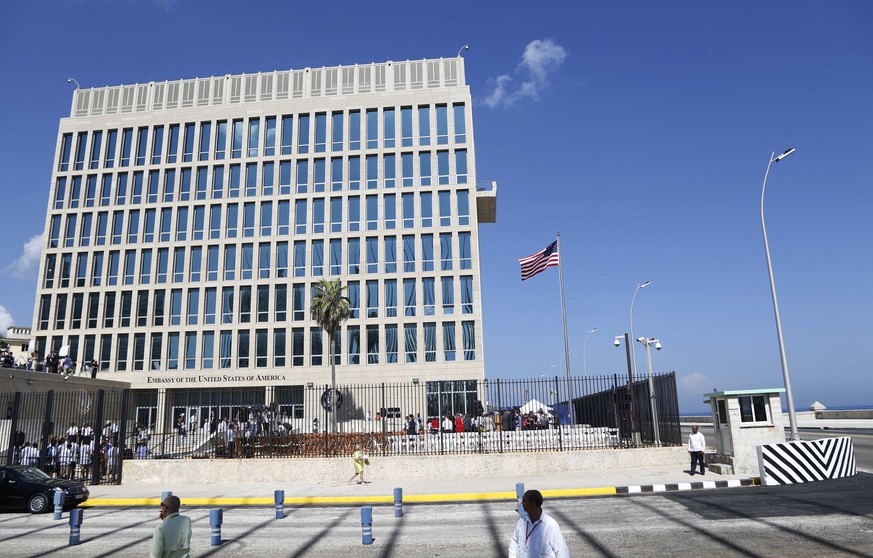 In this photo taken Aug. 14, 2015, a U.S. flag flies at the U.S. embassy in Havana, Cuba. At least 16 Americans associated with the U.S. Embassy in Havana suffered symptoms from attacks on their healt ...
