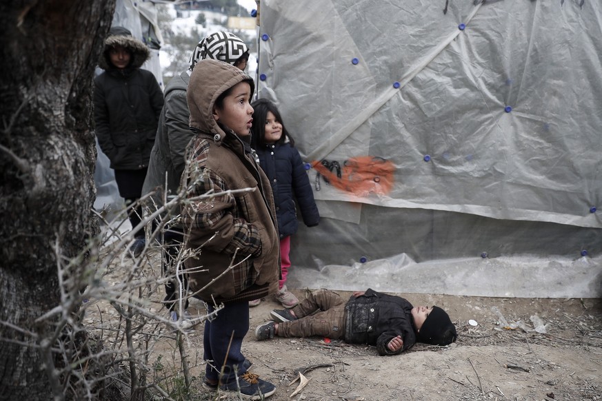epa08150012 Refugee children outside their tent in an olive yard next to the refugee camp of Moria, on Lesvos island, Greece, 21 January 2020 (issued 22 January 2020). The entire island of Lesvos amon ...