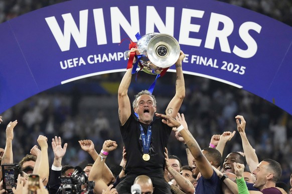 PSG's head coach Luis Enrique celebrates with the trophy after the Champions League final soccer match between Paris Saint-Germain and Inter Milan at the Allianz Arena in Munich, Germany, Saturda ...