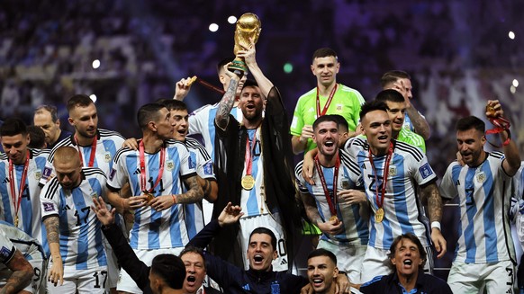 epa10373003 Lionel Messi (C) of Argentina lifts the trophy as his teammates celebrate after winning the FIFA World Cup 2022 Final between Argentina and France at Lusail stadium, Lusail, Qatar, 18 Dece ...