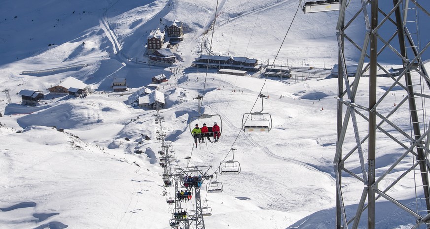 Skifahrer mit Schutzmaske auf dem Sessellift Lauberhorn aufgenommen am Freitag, 8. Januar 2021, im Skigebiet Grindelwald - Wengen. Die Berner Skigebiete bleiben trotz Coronavirus geoeffnet, mit reduzi ...