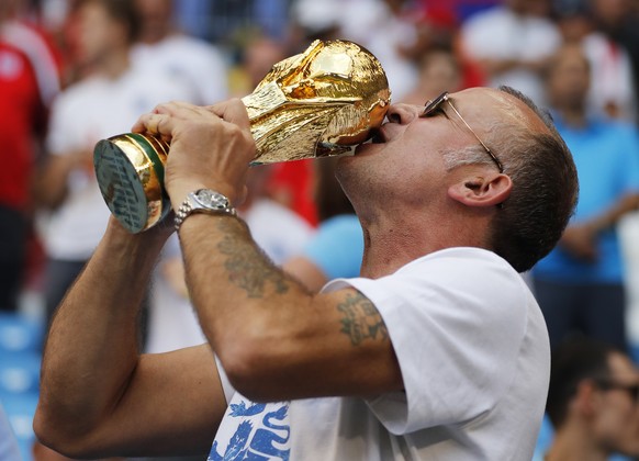 An England fan kisses a copy of the World Cup trophy prior the quarterfinal match between Sweden and England at the 2018 soccer World Cup in the Samara Arena, in Samara, Russia, Saturday, July 7, 2018 ...