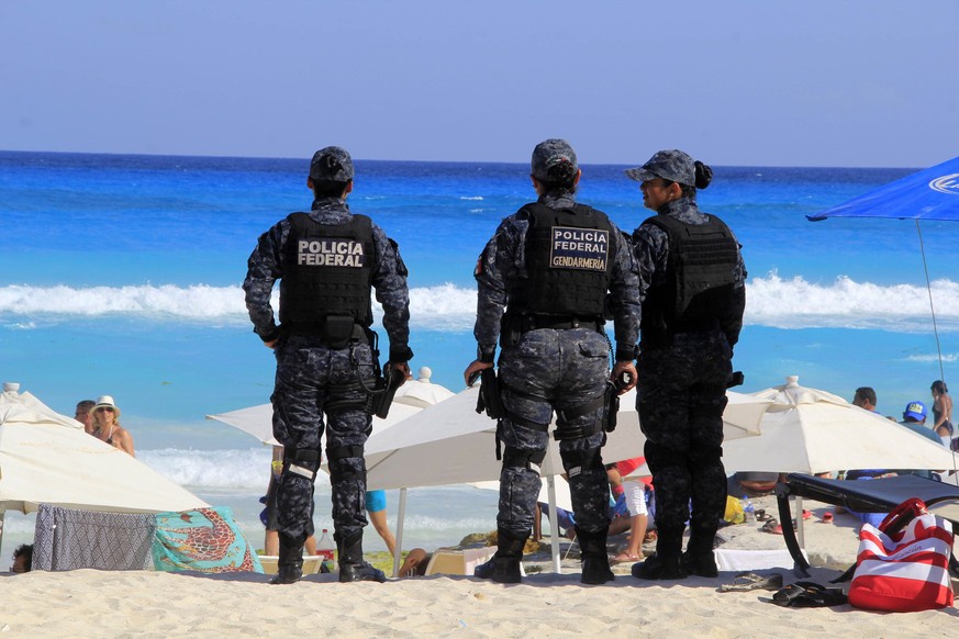 epaselect epa05904546 Tourists enjoy the sun and surf on a beach in Cancun, Mexico, 12 April 2017. Despite recent violent episodes in Mexico and the presence of armed Federal Police officers, tourists ...
