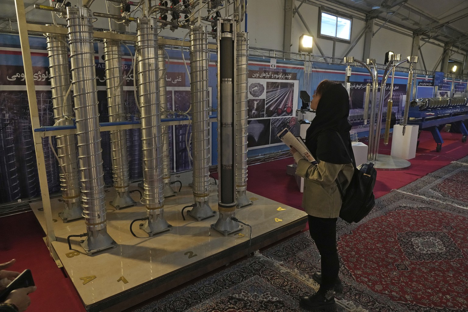 FILE -A student looks at Iran's domestically built centrifuges in an exhibition of the country's nuclear achievements, in Tehran, Iran, Wednesday, Feb. 8, 2023. Iran has further increased it ...