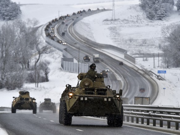 FILE - A convoy of Russian armored vehicles moves along a highway in Crimea, Jan. 18, 2022. Russia has concentrated an estimated 100,000 troops with tanks and other heavy weapons near Ukraine in what  ...