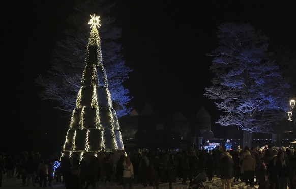 epa10357800 A Christmas tree made of solar panels is erected in Trakai, Lithuania, 09 December 2022. The Christmas tree from solar panels generates energy and illuminates itself and, after the festive ...