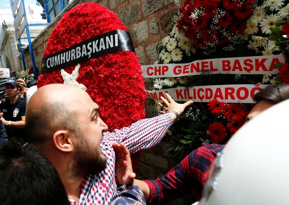 Ein Trauernder reist den Kranz von Kemal&nbsp;Kiliçdaroglu runter.