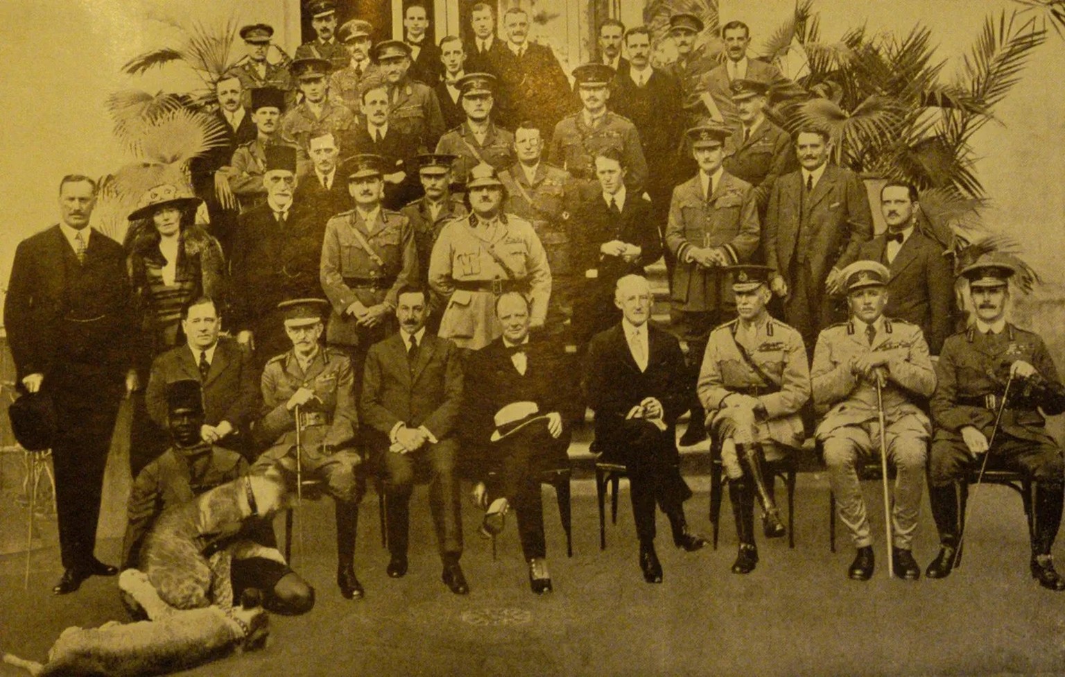 Gruppenbild der Kairo Konferenz vom März 1921. Gertrude Bell ist die einzige Frau. T. E. Lawrence steht rechts hinter Churchill mit schwarzem Anzug.
https://commons.wikimedia.org/wiki/File:Cairo_Confe ...