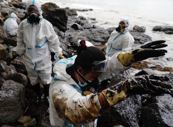 epa10505818 Filipino fishermen wearing protective suits collect oily waste along a beach in the coastal town of Pola, Mindoro island, Philippines, 06 March 2023. Affected fisherfolk were tapped by the ...