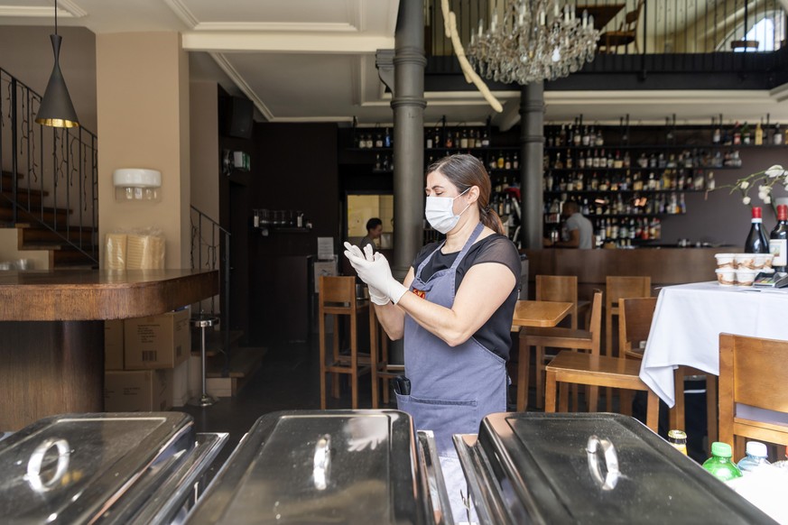 Maria Fernanda Pereira bereitet sich mit Gesichtsschutz und Handschuhen vor fuer den als Notloesung eingerichteten Take Away Service im Restaurant ONO deli cafe bar in Basel, am Freitag, 8. Mai 2020.  ...