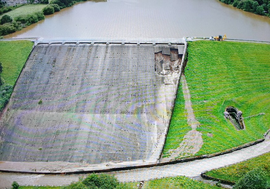 epa07753244 A handout photo made available by the Derbyshire Constabulary police force shows an aerial view of damage to the Toddbrook Reservoir dam above the town of Whaley Bridge, in northern Englan ...