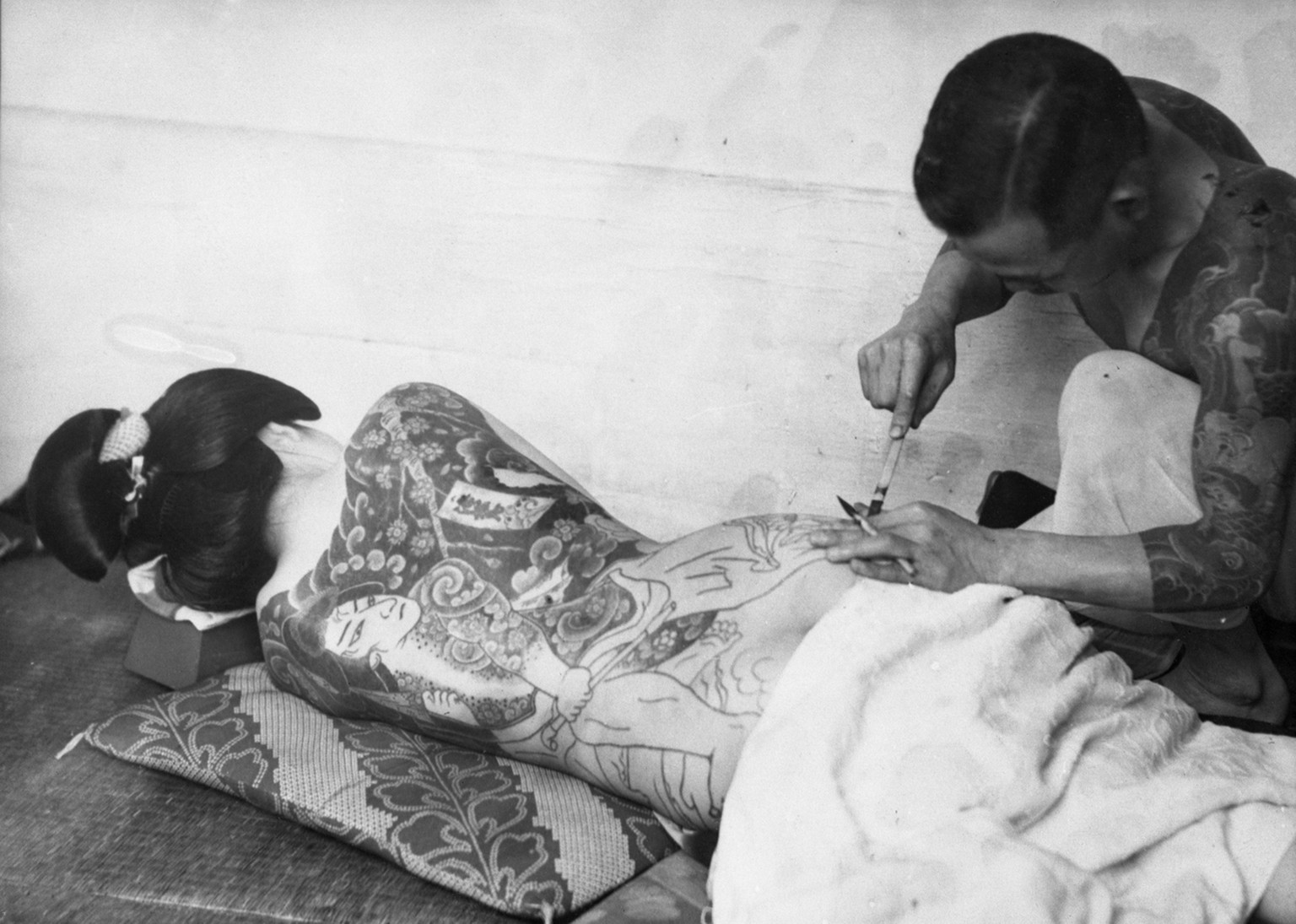 A tattoo artist traces work on a Japanese woman circa June 22, 1937. It often takes up to three years to complete a tattoo as large and detailed as this one. (AP Photo)