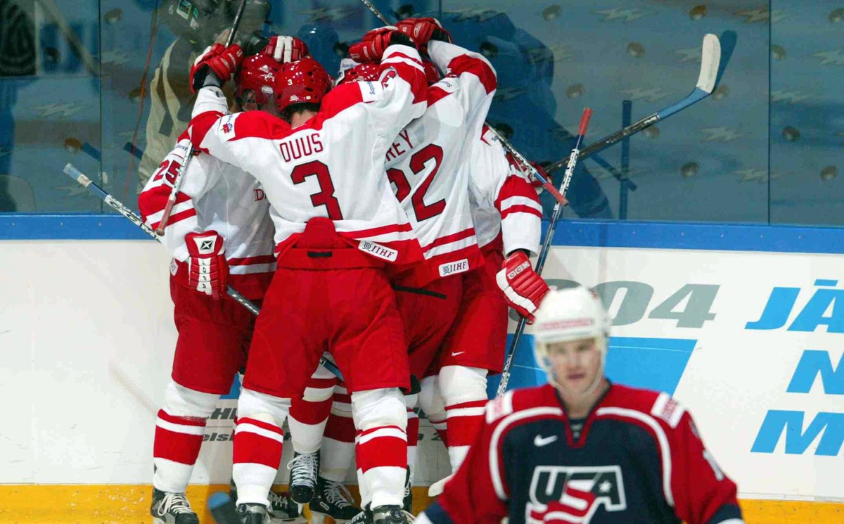 Denmark's national ice hockey team celebrates its first goal during the Hockey World Championship match between USA and Denmark in Tampere, Finland, on Saturday April 26, 2003. In front is US pla ...