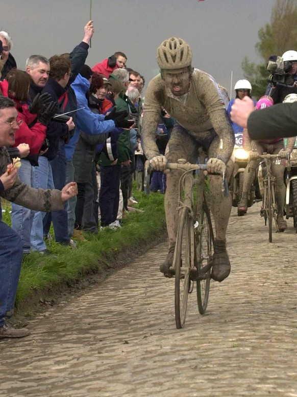 BRU68 - - ROUBAIX, FRANCE: Belgian Johan Museeuw passes under a Belgian flag during the famous cycling race Paris - Roubaix , 3 rd round of the World Cup, Sunday 15 April 2001, in Roubaix. The Domo te ...