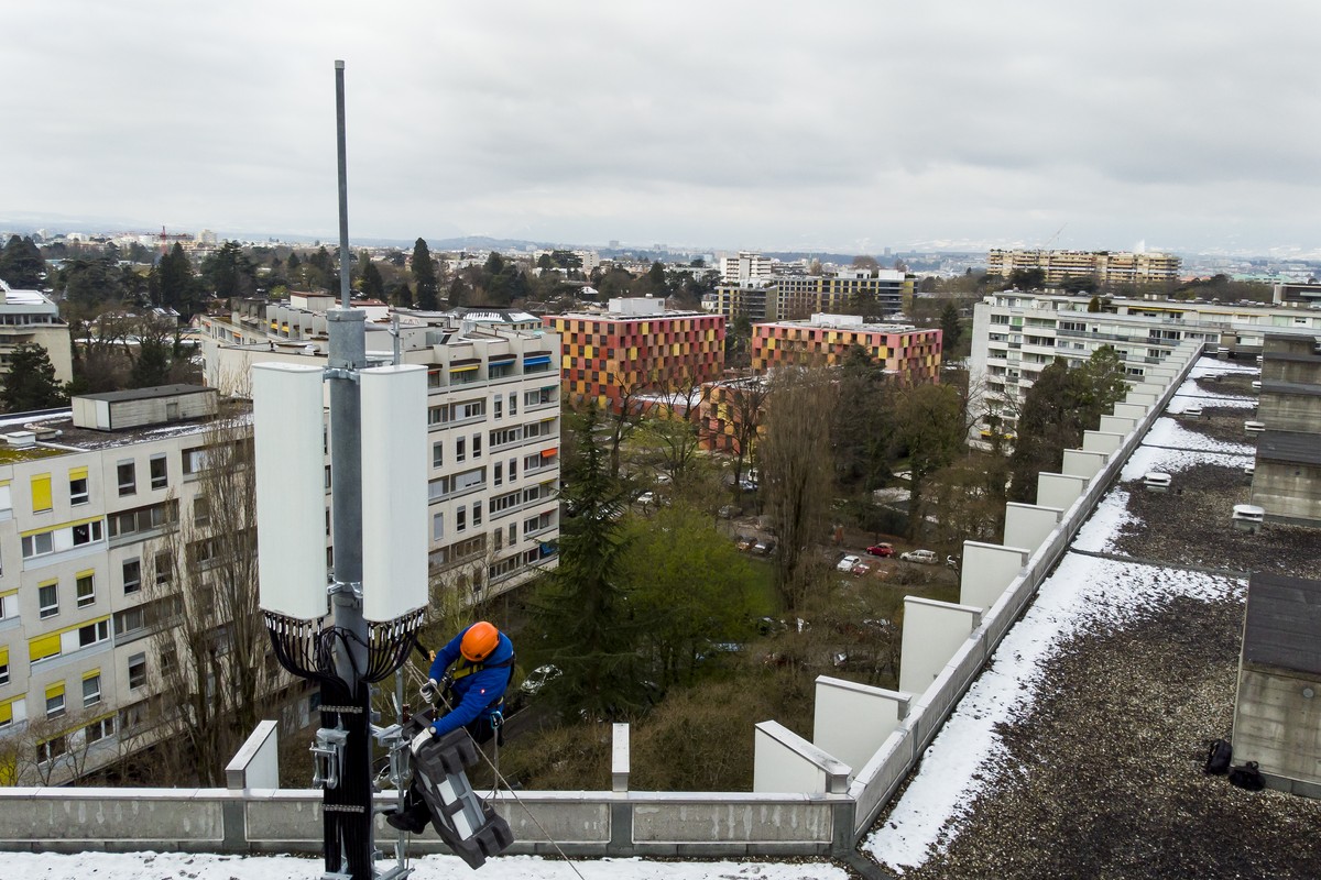 Un employe de de l'entreprise Axians installe une antenne 5G sur un mat situe sur le toit d'un immeuble du quartier de la Gradelle a Chene-Bougeries ce vendredi 5 avril 2019 dans le canton d ...
