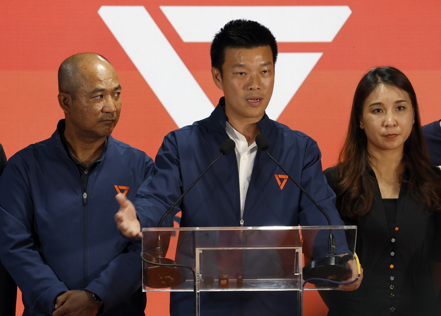 epa12717232 Leader of the People's Party and prime ministerial candidate Natthaphong Ruengpanyawut (C) speaks next to secretary-general Sarayut Jailak (L) and Sirikanya Tansakun (R) during a pres ...