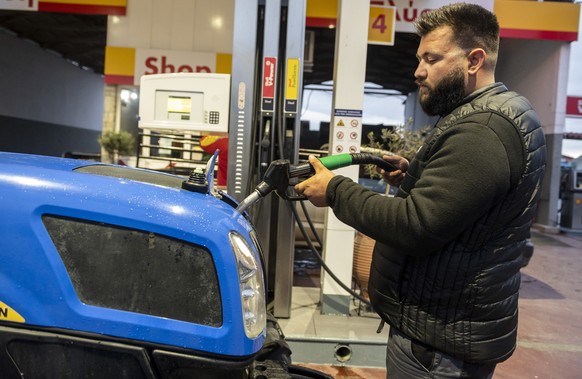 Farmer Dimitris Kakalis, 25, fills his tractor with diesel at a gas station, in Tyrnavos town, central Greece, Sunday, Feb. 13, 2022. Economists, farmers and charity workers agree about a cost-of-livi ...