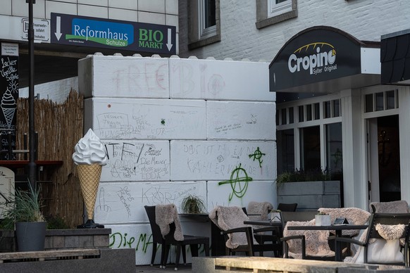 Ein Mann wurde mit Klebebank an diese Mauer in Westerland geklebt: Die Punks wollen mit der Aktion Kritik an der baulichen Massnahme der Gemeinde üben.