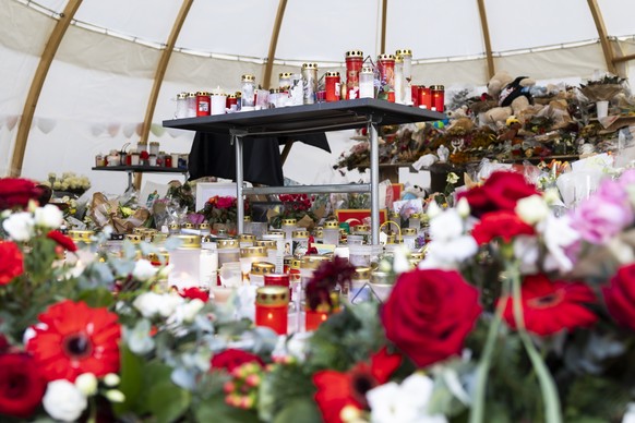 epa12648736 Flowers and candles are left in tribute to the victims after the fire at a bar in Crans-Montana, Switzerland, 14 January 2026. 40 people mostly teenagers lost their lives and 116 were seve ...
