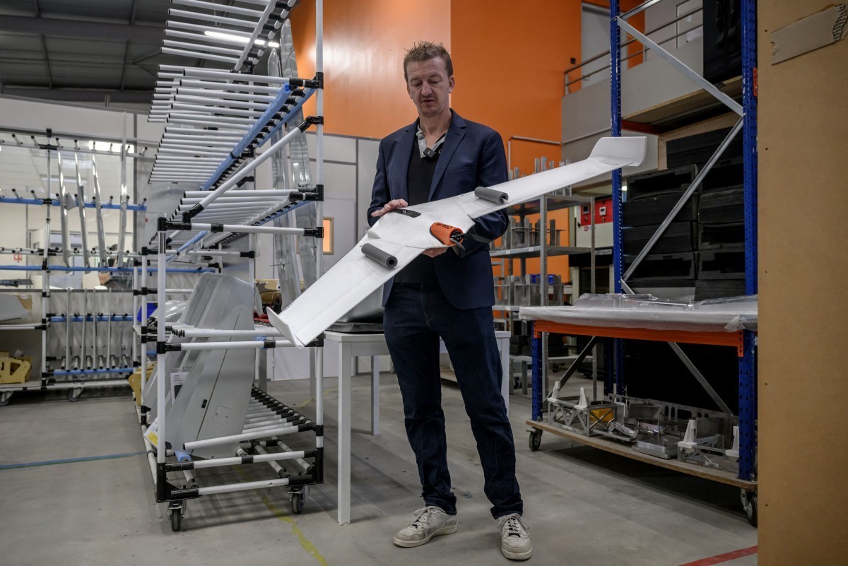 Delair's co-founder Bastien Mancini holds an 'Oskar' drone, capable of carrying warheads for military use, at the company's factory in Labege, south-western France, on April 11, 20 ...