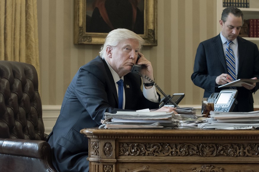 epa07873309 (FILE) - US President Donald J. Trump (L) speaks on the phone with President of Russia Vladimir Putin, with White House Chief of Staff Reince Priebus (R) behind, in the Oval Office of the  ...