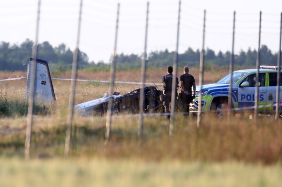 epaselect epa09332445 Officers stand next to the wreckage of crashed plane at Orebro Airport, Sweden, 08 July 2021. A small plane used by the local parachute club with nine people on board crashed at  ...
