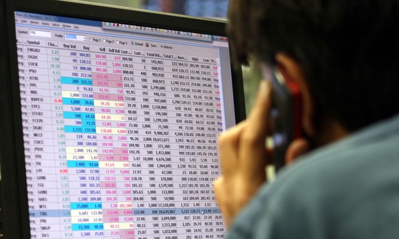 epa09013916 A Pakistani stock broker watches monitors showing the latest share prices during a trading session at the Pakistan Stock Exchange (PSX) in Karachi, Pakistan, 15 February 2021. The Pakistan ...