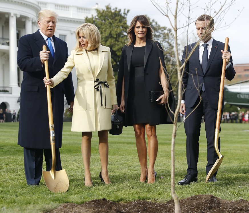 epa06688018 US President Donald J. Trump (L) and First Lady Melania Trump (2R) with French President Emmanuel Macron (R) and his wife Brigitte Macron (2L) as they participate in a tree planting in fro ...