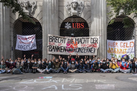 Menschen der Gruppierung von &quot;Rise Up for Change&quot; sitzen vor der UBS unter dem Motto &quot;Transparenz aller Finanzfluesse&quot; an der Bahnhofstrasse, aufgenommen am Montag, 2. August 2021  ...