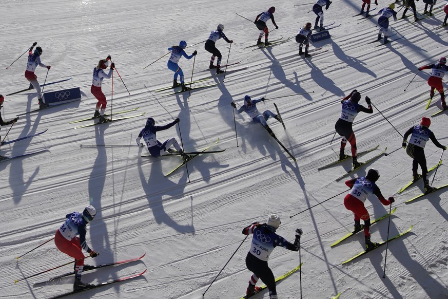 Skiers fall while competing during the women&#039;s 7.5km + 7.5km skiathlon cross-country skiing competition at the 2022 Winter Olympics, Saturday, Feb. 5, 2022, in Zhangjiakou, China. (AP Photo/John  ...