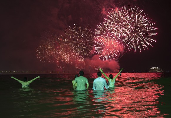 People watch the fireworks exploding over Copacabana beach during the New Year&#039;s Eve celebrations in Rio de Janeiro, Brazil, Sunday, Jan. 1, 2017. (AP Photo/Leo Correa)