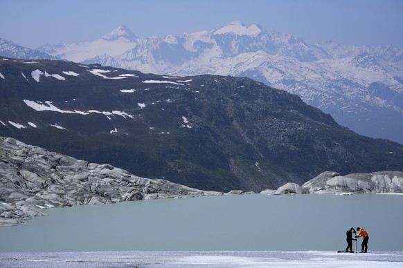 Matthias Huss, of the Federal Institute of Technology in Zurich and glacier monitoring group GLAMOS, and Monica Ursina Jaeger prepare a camera at the Rhone Glacier near Goms, Switzerland, June 10, 202 ...