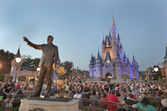 In this Wednesday, Jan. 15, 2020 photo, a statue of Walt Disney and Mickey Mouse is seen in front of the Cinderella Castle at the Magic Kingdom theme park at Walt Disney World in Lake Buena Vista, Fla ...