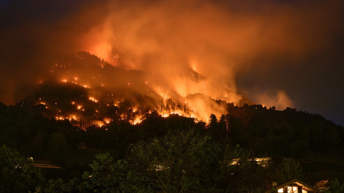 De la fumee et des flammes s'echappent de la foret en feu au dessus des communes de Bitsch et Ried-Moerel ce lundi 17 juillet 2023 depuis Naters. Un incendie de foret s'est declare lundi au- ...