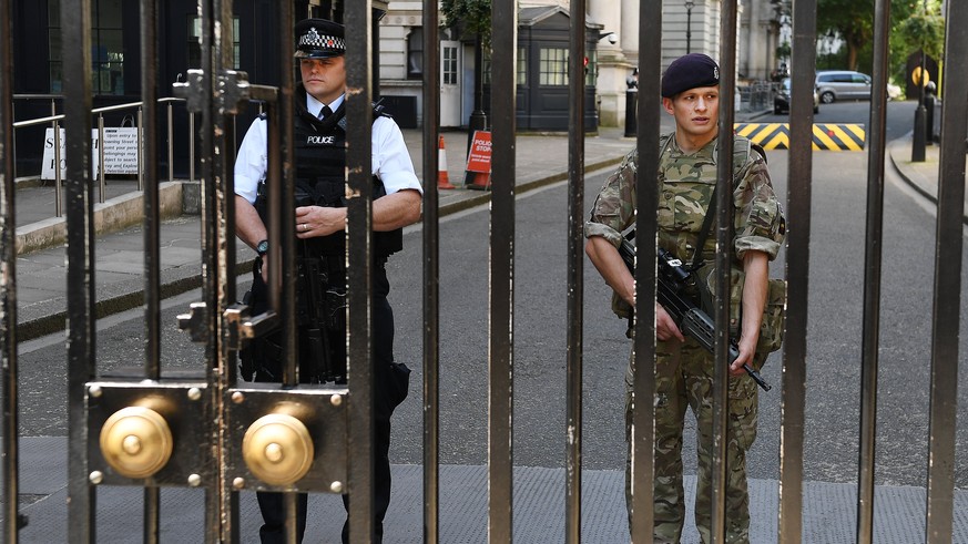 epa05991506 Police and the military on guard in tandem at Downing Street in central London, Britain, 26 May 2017. Britain is on high alert following the Manchester terror attack on the Manchester Aren ...