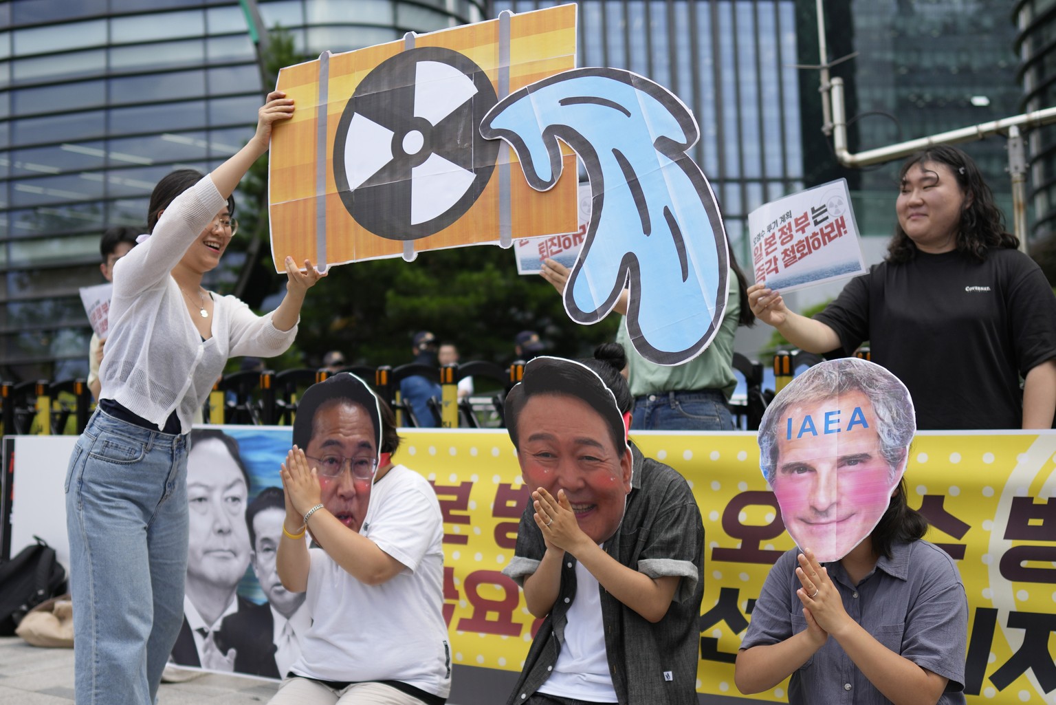 Students wearing masks of, from left, Japanese Prime Minister Fumio Kishida, South Korean President Yoon Suk Yeol and Rafael Mariano Grossi, director general of the International Atomic Energy Agency, ...