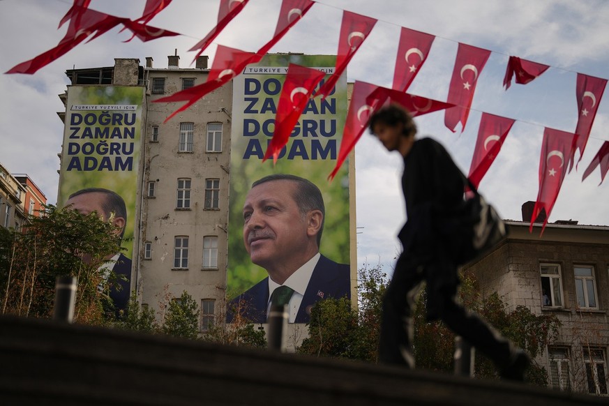 A man walks past billboards displaying Turkish President Recep Tayyip Erdogan and read in Turkish: &quot;For the Turkish century, the right time, the right man&quot; in Istanbul, Turkey, Friday, Nov.  ...