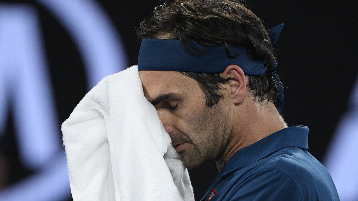 Switzerland's Roger Federer wipes the sweat from his face during his fourth round match against Greece's Stefanos Tsitsipas at the Australian Open tennis championships in Melbourne, Australi ...