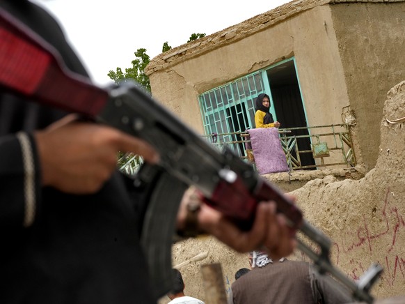 A Taliban fighter stands guard at the site of an explosion in front of a school, in Kabul, Afghanistan, Tuesday, April 19, 2022. An Afghan police spokesman says explosions targeting educational instit ...