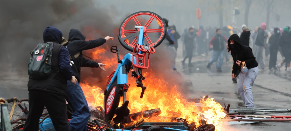 epaselect epa13291737 Protesters throw a shared bicycle into a burning pile during a demonstration organized by national trade unions against the federal government's planned economic and wage re ...