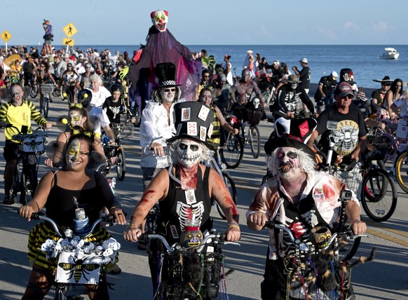 In this photo provided by the Florida Keys News Bureau, costumed revelers cycle during the Zombie Bike Ride, Sunday, Oct. 21, 2018, in Key West, Fla. The event, that attracted more than 6,500 particip ...