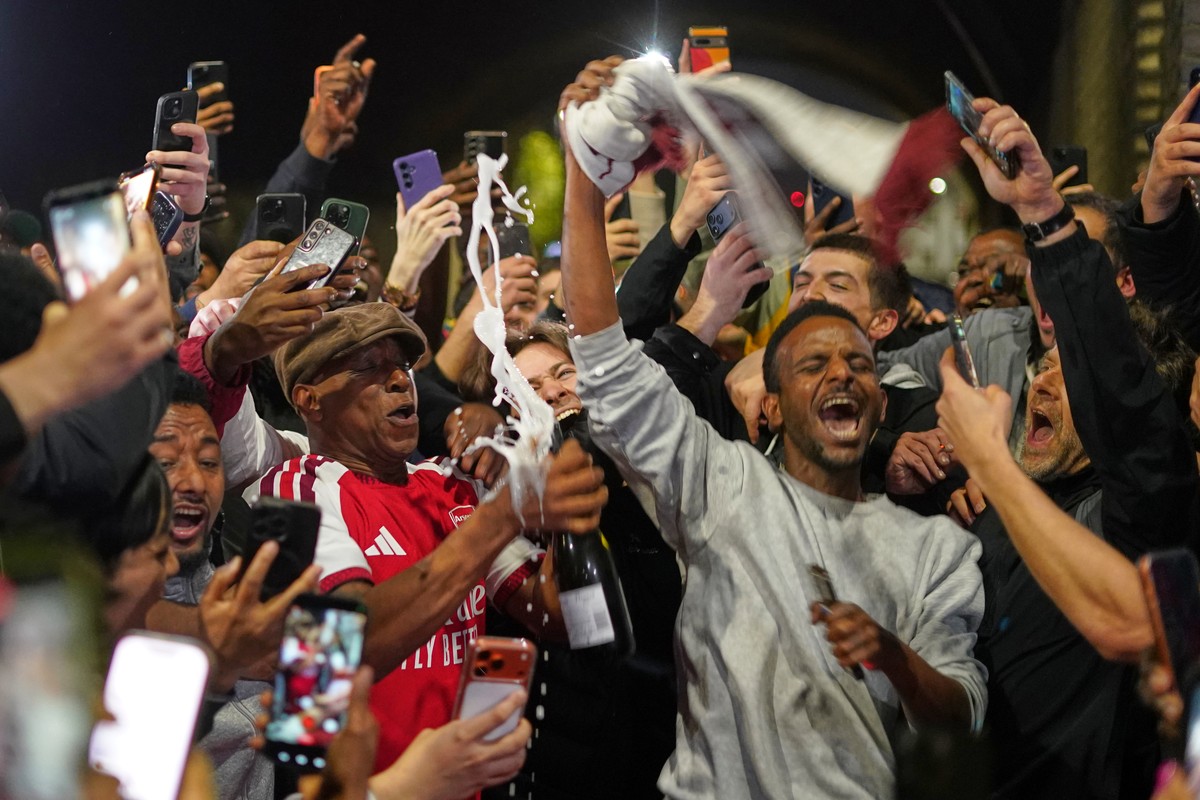 Former Arsenal player Ian Wright celebrates with Arsenal supporters at the Arsenal stadium after Arsenal's soccer team won the Premier League title in London, Tuesday, May 19, 2026.(AP Photo/Albe ...