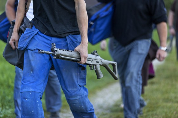 Soldiers carrying their rifles on their way to the mandatory firing practice, pictured on August 31, 2011, in Trub in Emmental in the Canton of Berne, Switzerland. (KEYSTONE/Martin Ruetschi)

Soldaten ...