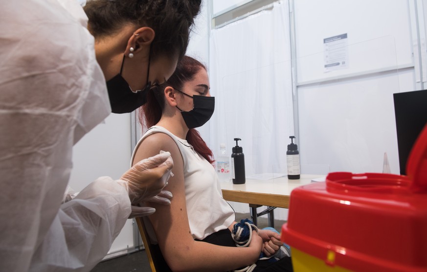 Eine junge Frau erhaelt im Impfzentrum von Giubiasco am Dienstag, 29. Juni 2021, ihre Corona-Impfung. Im Tessin werden zurzeit junge Leute in zwei Gruppen fuer unter 16-Jaehrige und ueber 16-Jaehrige  ...